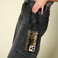 Petra Karthaus black leather knotted wristlet phone lanyard with tiger print card holder attached to a phone.