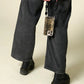 Petra Karthaus black leather knotted wristlet phone lanyard with tiger print phone case attached.